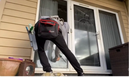 Technician cleaning patio doors with a backpack water-fed system